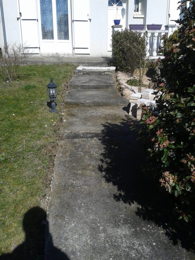 Aménagement d'une allée bétonnée avec marches devant porte d'entrée par Entre Pierres et Vert