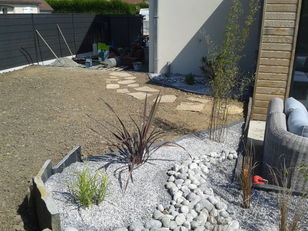 Aménagement d'un jardin avec dalles, graviers, galets et ardoises par Entre Pierres et Vert